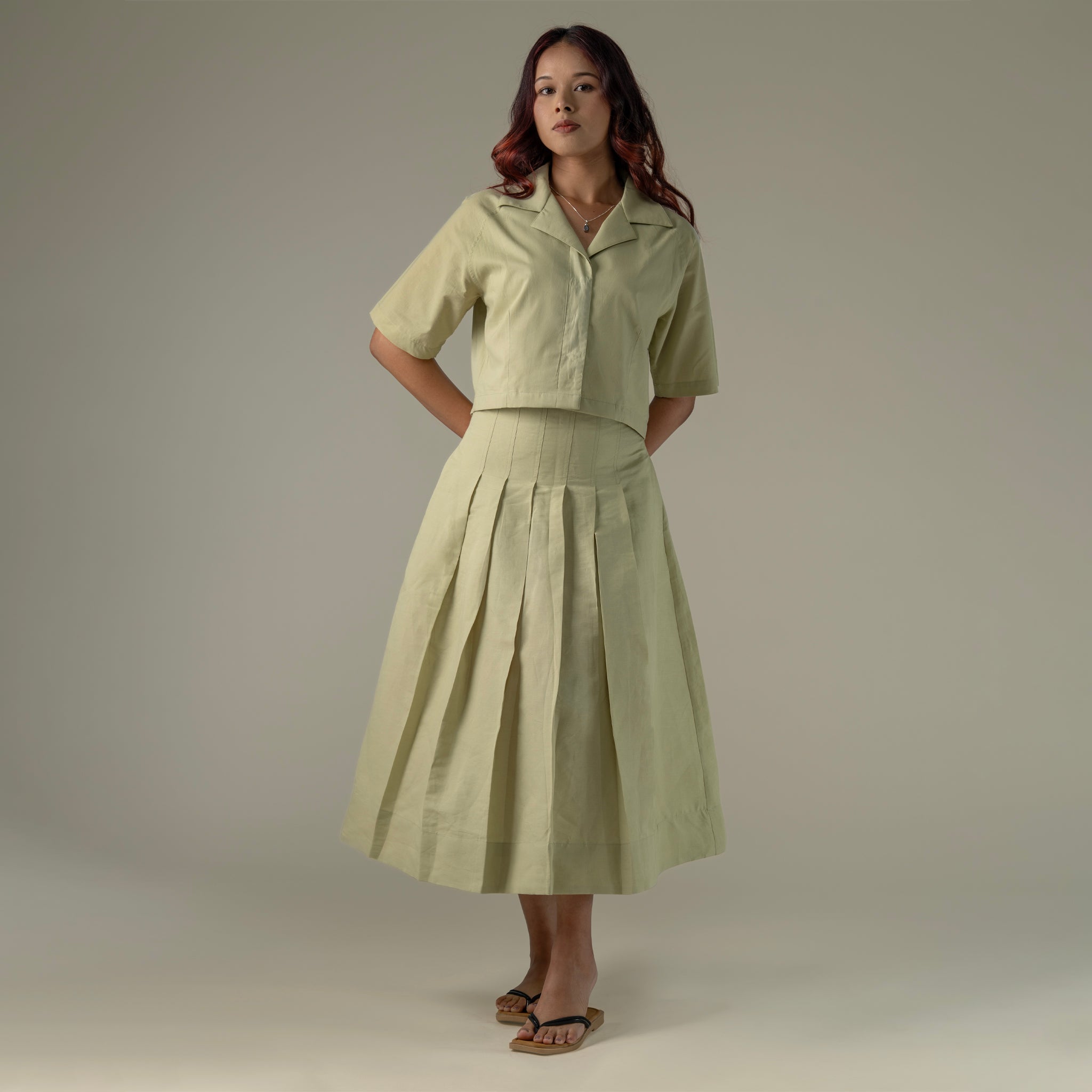 Woman wearing a light green outfit against a plain background